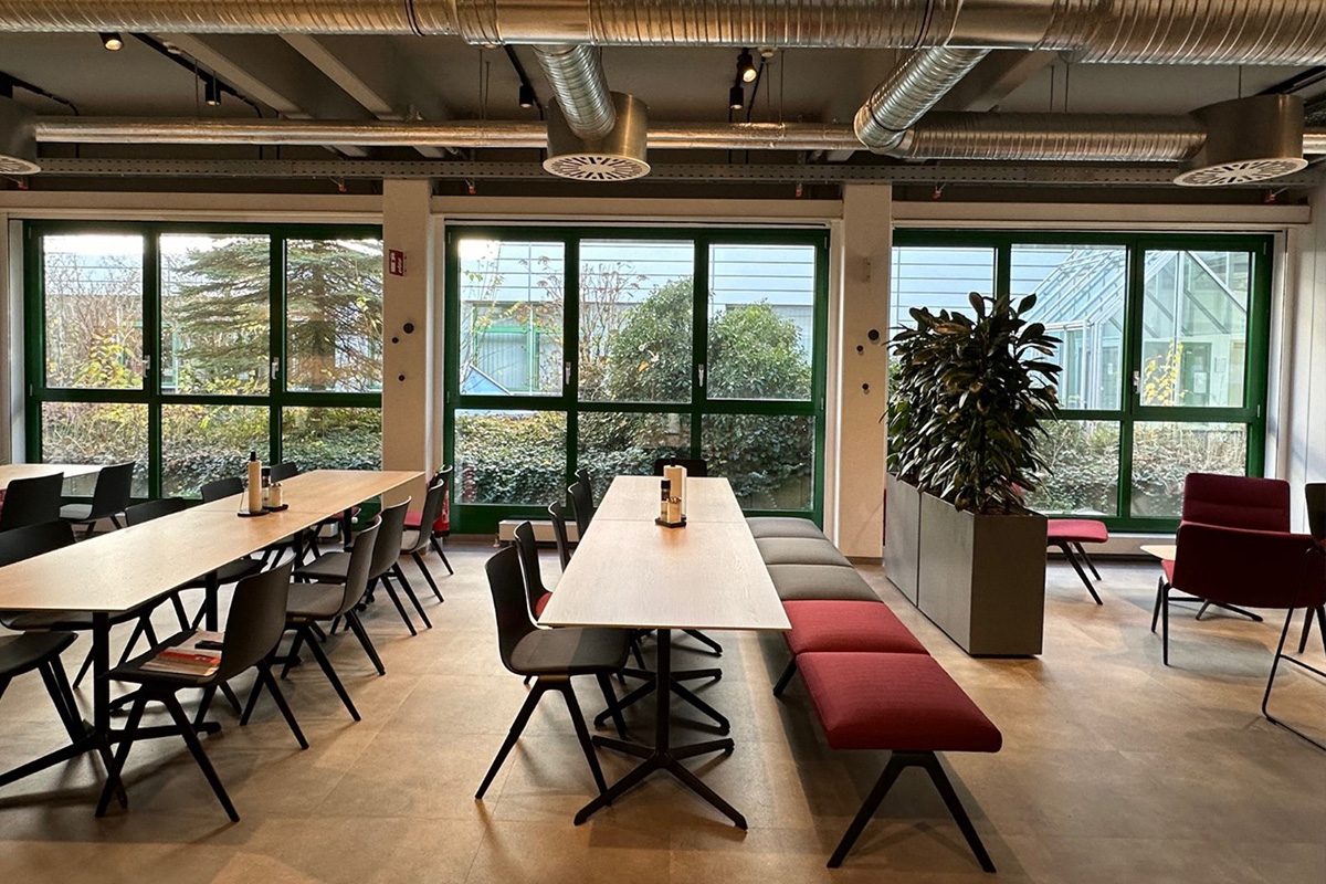 Der Empfangsbereich von CS Clean Solutions mit modernem Design, roten Sesseln und dem Firmenlogo, das den Raum dominiert.