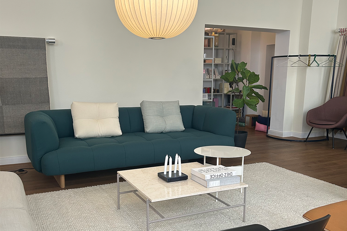 Besuch im HAY Showroom München: Einladende Lounge-Atmosphäre mit modernen Möbeln, darunter das markante Quilton Sofa, eine stilvolle Pendelleuchte und harmonisch abgestimmte Accessoires.