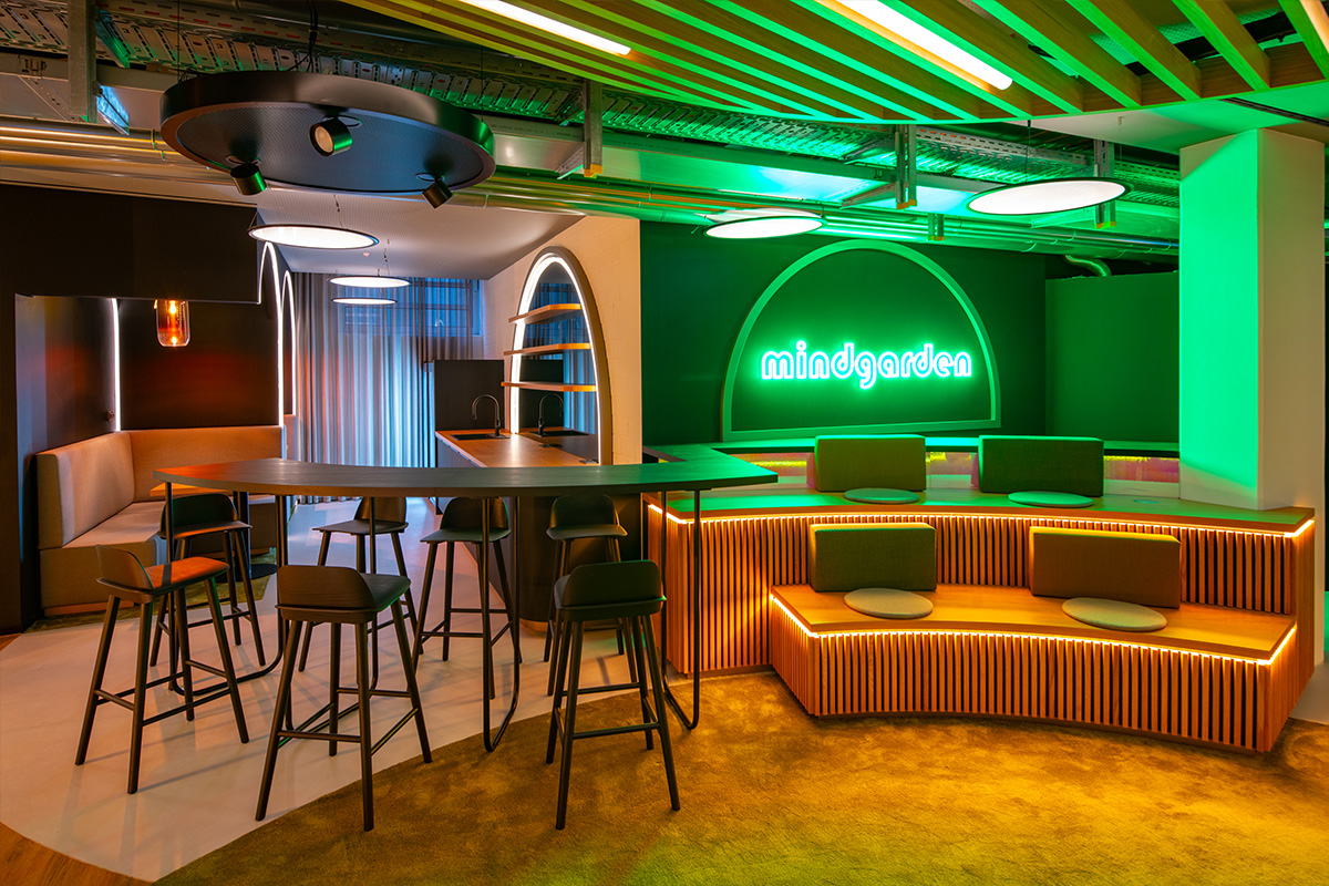 Das ist ein weiterer Bereich des Projekts Mindgarten bei der Allgemeinen Südboden in München, realisiert von Hauser. Der Raum zeigt ein modernes, modulares Kommunikations- und Begegnungsareal mit flexibler Möblierung, Lounge-Zonen, akzentuierter Beleuchtung und einem kreativen Farbkonzept. Perfekt für Workshops, Vorträge oder informellen Austausch.