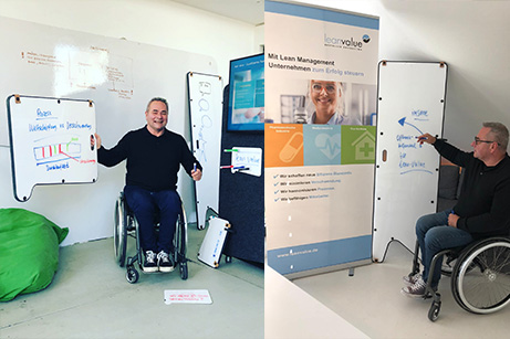 Eine Person im Rollstuhl nutzt verschiedene Imsinne Whiteboards während einer Präsentation, inklusive eines digitalen Displays, das die vielfältige und behindertengerechte Nutzbarkeit von Imsinne Büroprodukten zeigt.