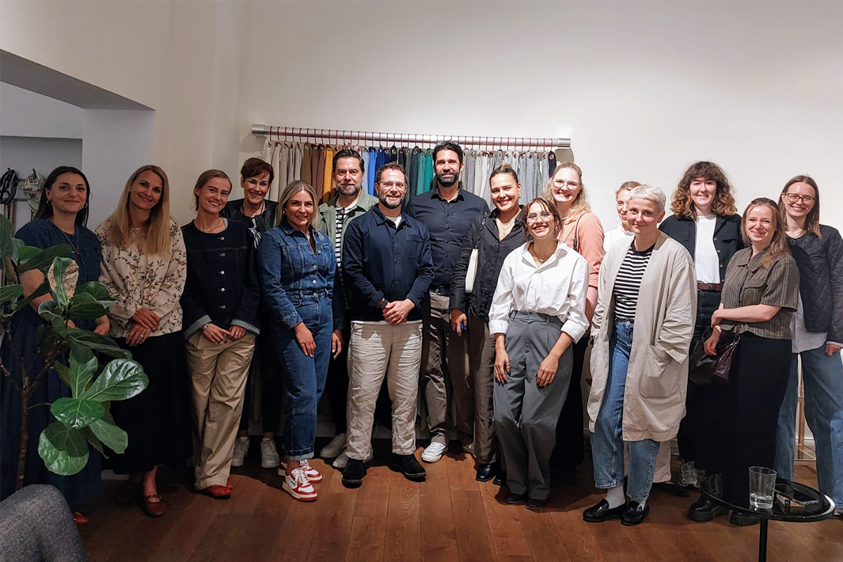 Gruppenfoto mit Bertie van Wyk, Hauser und HAY  eines Interior-Events, aufgenommen vor einem Vorhang mit Stoffmustern in verschiedenen Farben. Alle stehen entspannt lächelnd im stilvollen Showroom und spiegeln die kreative und offene Atmosphäre des Treffens wider.