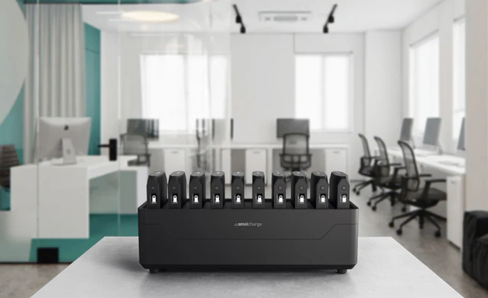 Omnicharge Powerstation mit mehreren mobilen Akkus auf einem Schreibtisch in einem modernen Büro.
